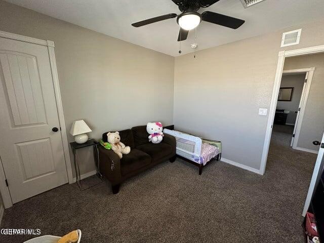 living room featuring dark colored carpet and ceiling fan