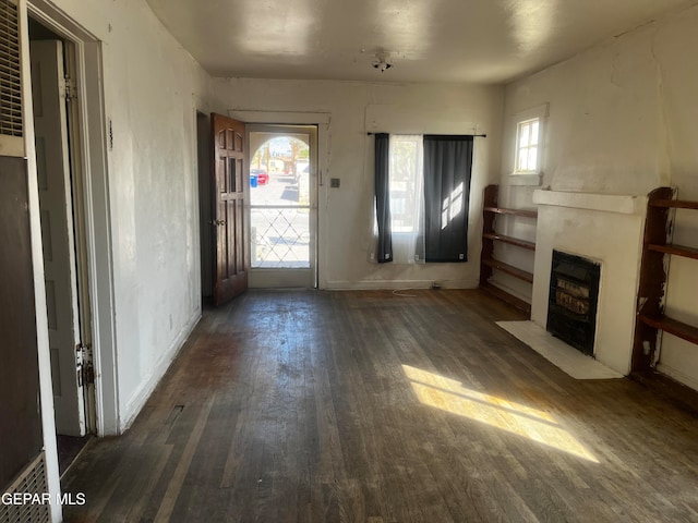 unfurnished living room with a healthy amount of sunlight and dark hardwood / wood-style flooring