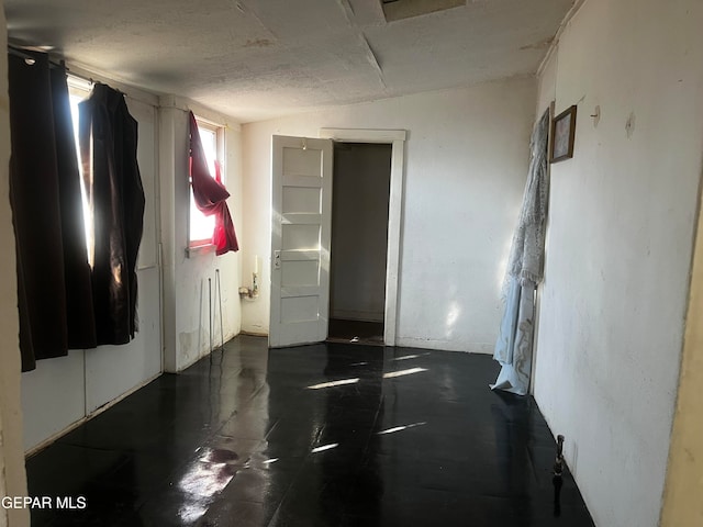 spare room featuring lofted ceiling and a textured ceiling