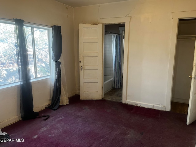 unfurnished bedroom with a closet and dark colored carpet