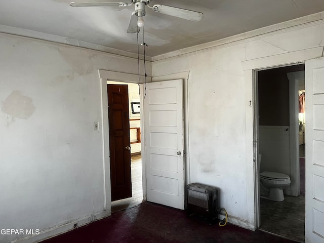 unfurnished bedroom with ornamental molding, connected bathroom, heating unit, and ceiling fan