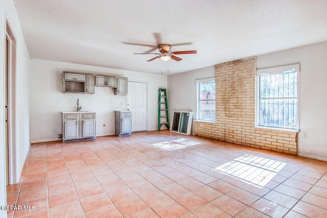 unfurnished living room featuring light tile patterned flooring, a textured ceiling, and ceiling fan