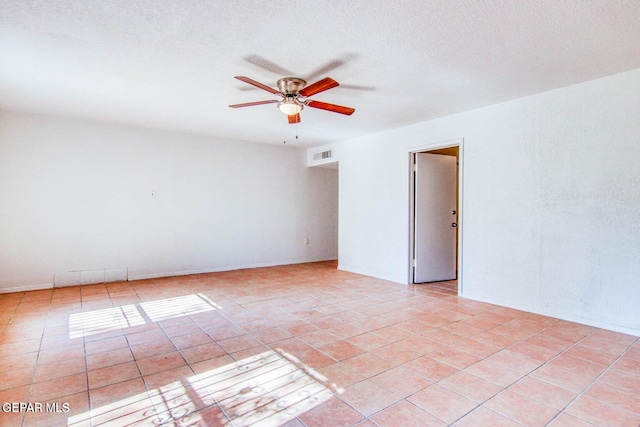 tiled empty room featuring a textured ceiling and ceiling fan