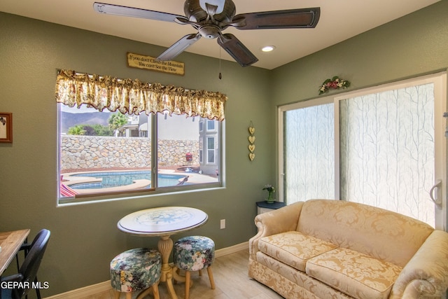 living area featuring ceiling fan and a healthy amount of sunlight