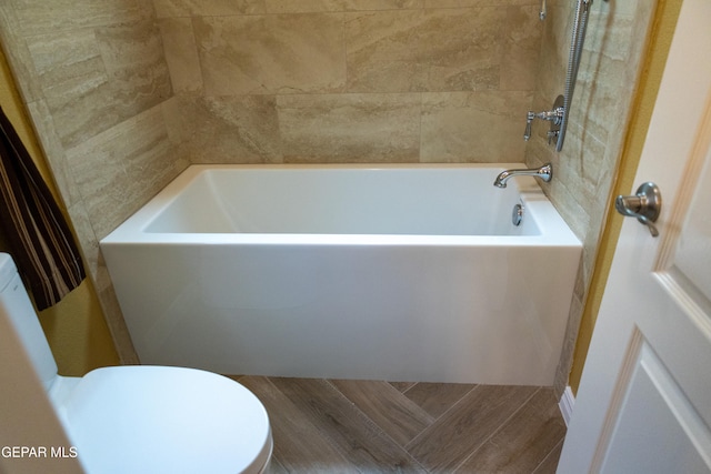 bathroom featuring toilet, wood-type flooring, and a bathing tub