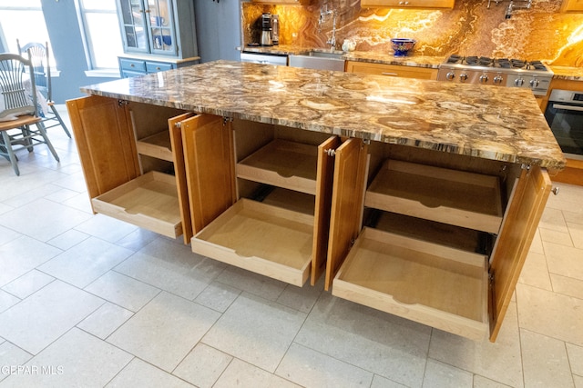 bar with backsplash, sink, light tile patterned floors, appliances with stainless steel finishes, and light stone counters