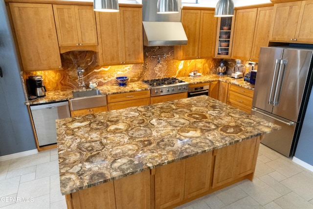 kitchen featuring appliances with stainless steel finishes, wall chimney exhaust hood, decorative backsplash, and light stone countertops