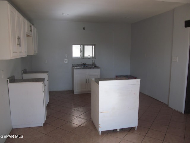 kitchen featuring white cabinetry, sink, and light tile patterned floors