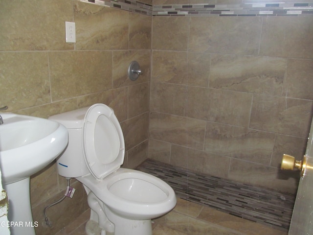 bathroom featuring toilet, tile walls, tile patterned flooring, and tiled shower