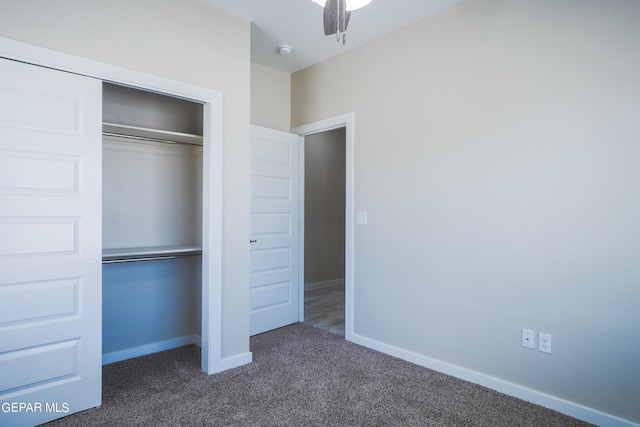 unfurnished bedroom with a closet, ceiling fan, and dark colored carpet