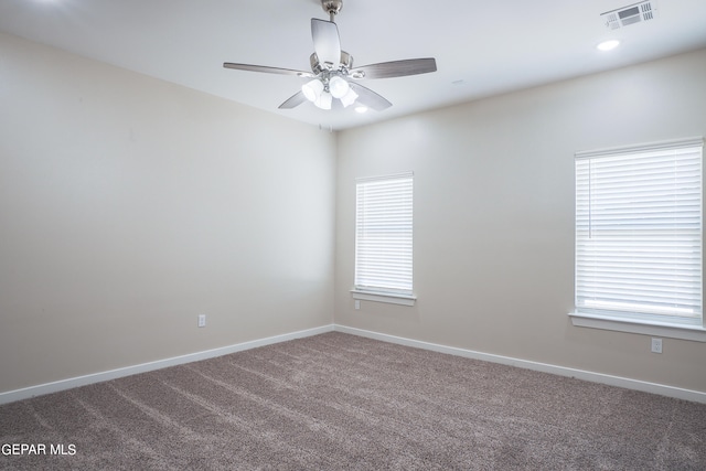 spare room featuring a wealth of natural light, carpet flooring, and ceiling fan