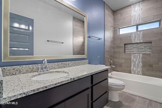 full bathroom featuring vanity, tiled shower / bath combo, and toilet