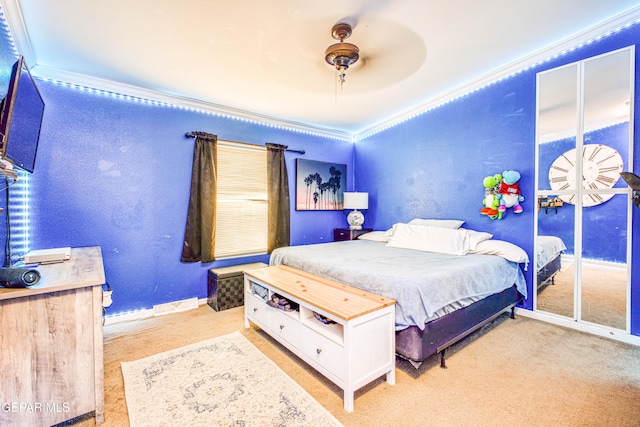 carpeted bedroom with crown molding, a closet, and ceiling fan