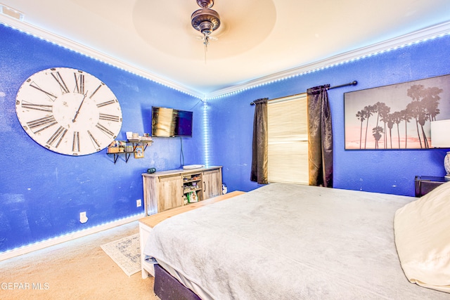 carpeted bedroom with ornamental molding and ceiling fan