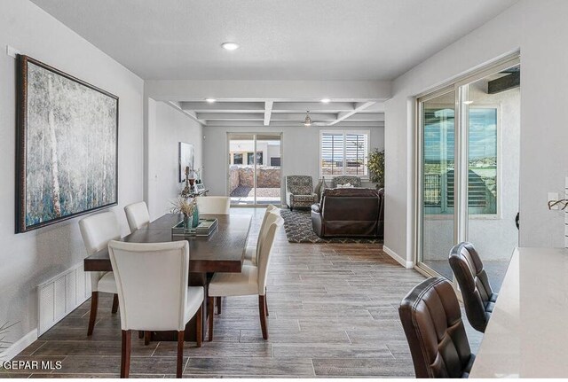 dining room featuring coffered ceiling and beam ceiling