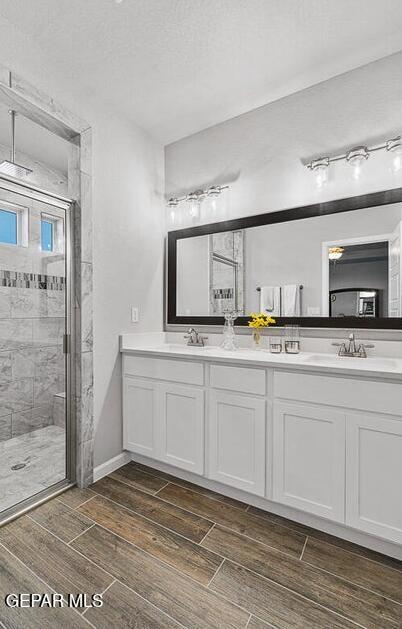 bathroom with a tile shower and vanity