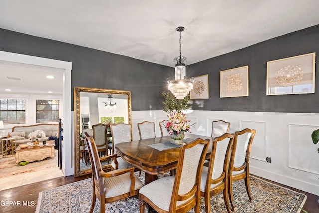 dining space with an inviting chandelier and dark hardwood / wood-style flooring