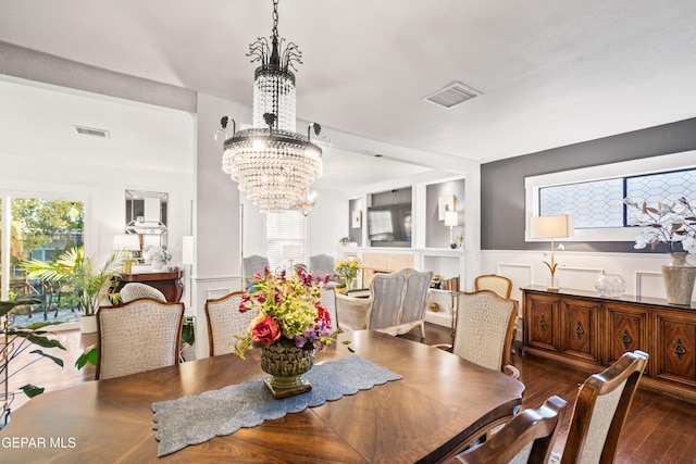 dining area featuring a notable chandelier, plenty of natural light, and dark hardwood / wood-style floors