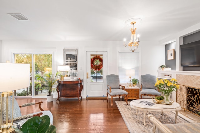 sitting room featuring an inviting chandelier and dark hardwood / wood-style flooring