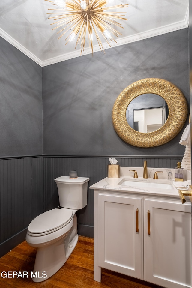 bathroom featuring vanity, ornamental molding, hardwood / wood-style flooring, and toilet