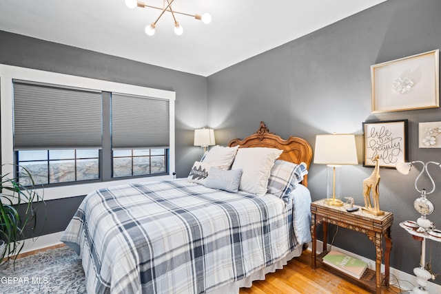 bedroom with light hardwood / wood-style floors and a chandelier