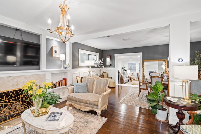 living room with a notable chandelier and dark hardwood / wood-style flooring