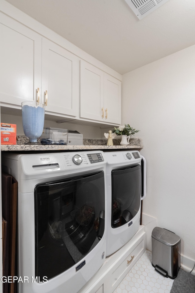 washroom with independent washer and dryer and cabinets