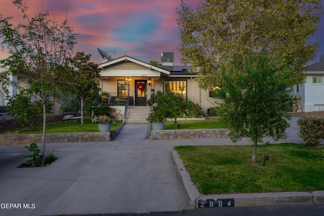 view of front of house with a lawn and a porch