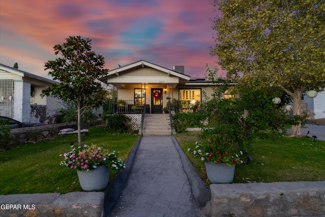 view of front of house with a yard and a porch