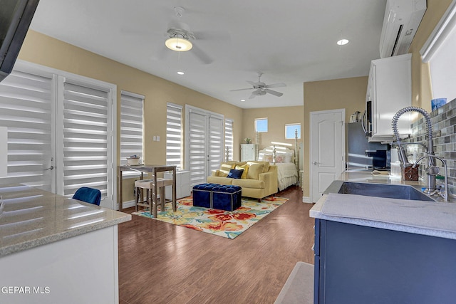 living room featuring sink, dark wood-type flooring, and ceiling fan