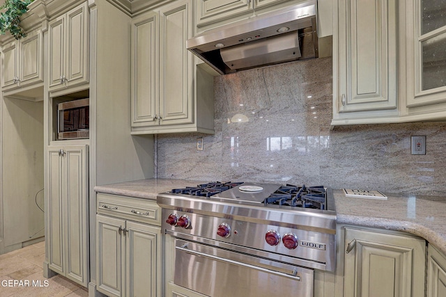 kitchen featuring decorative backsplash, light stone counters, ventilation hood, and cream cabinetry