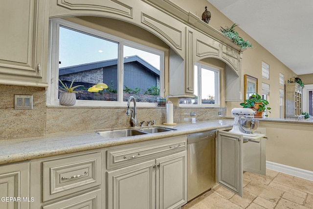 kitchen featuring stainless steel dishwasher, sink, backsplash, and cream cabinetry