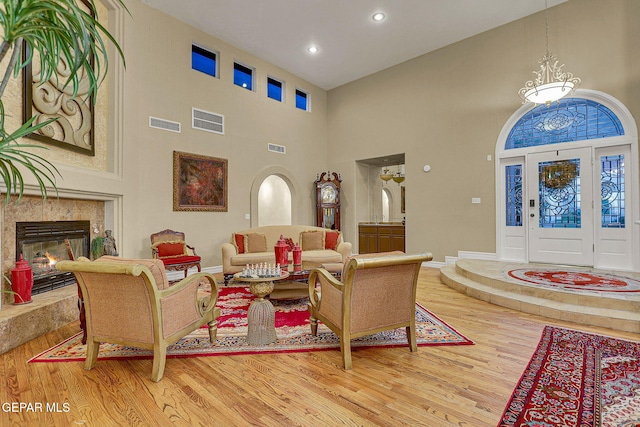 living room featuring a fireplace, hardwood / wood-style flooring, and high vaulted ceiling