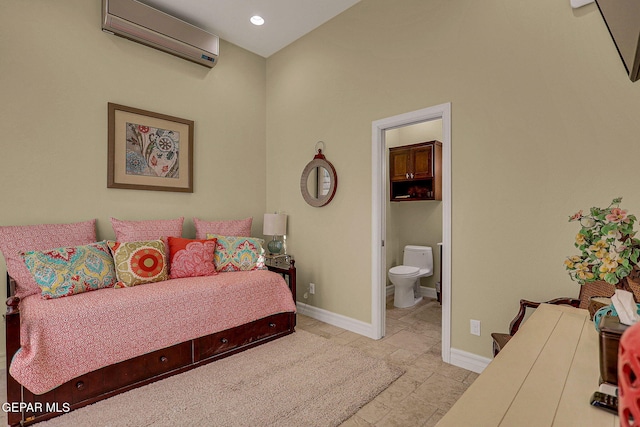 bedroom with an AC wall unit and ensuite bathroom