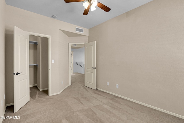 unfurnished bedroom featuring light carpet, a closet, and ceiling fan