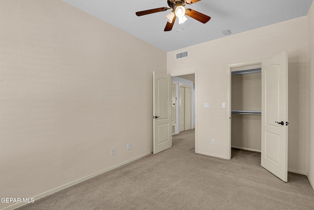 unfurnished bedroom with a closet, light colored carpet, and ceiling fan