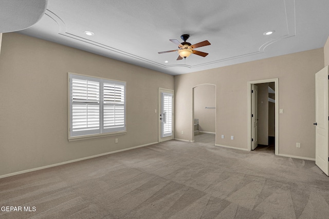 unfurnished bedroom with light carpet, ceiling fan, and ensuite bath