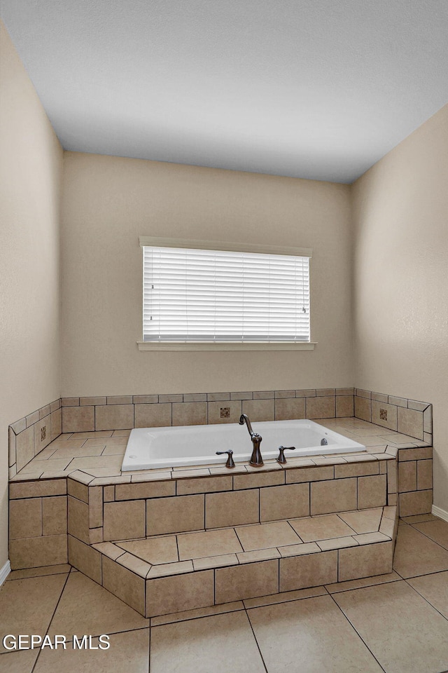 bathroom featuring tile patterned flooring, a relaxing tiled tub, and plenty of natural light