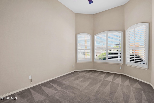 carpeted spare room with ceiling fan