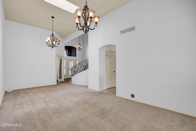 carpeted empty room with high vaulted ceiling