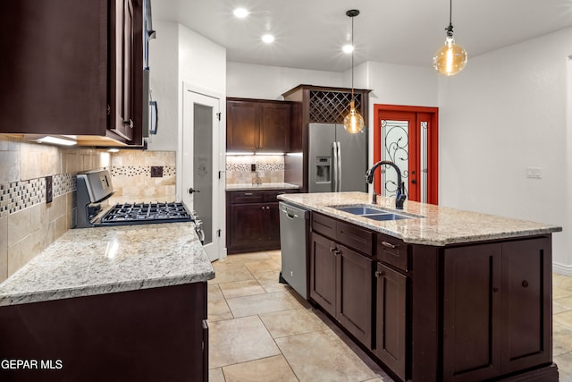 kitchen with sink, a kitchen island with sink, decorative light fixtures, and stainless steel appliances