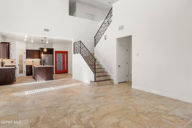 unfurnished living room featuring a high ceiling