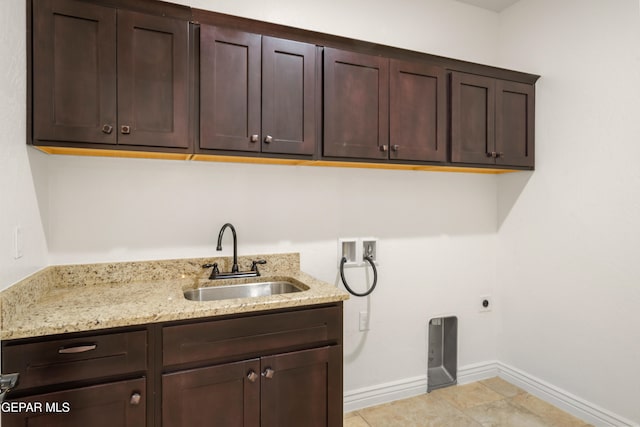 laundry room with cabinets, light tile patterned floors, hookup for a washing machine, hookup for an electric dryer, and sink