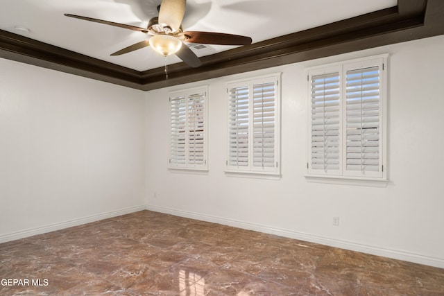 spare room featuring crown molding, a tray ceiling, and ceiling fan