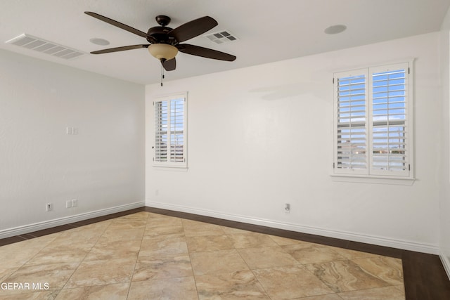 empty room featuring a wealth of natural light and ceiling fan