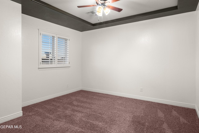 carpeted empty room featuring a tray ceiling and ceiling fan