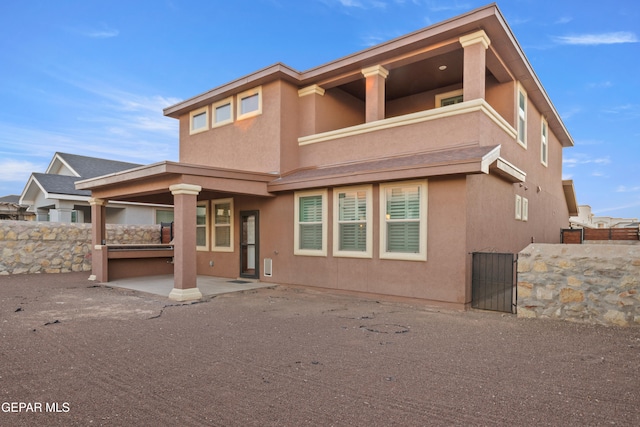 rear view of house with a balcony and a patio