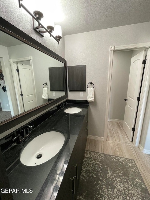 bathroom featuring vanity, a textured ceiling, hardwood / wood-style flooring, and an inviting chandelier