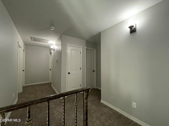 hallway featuring dark carpet