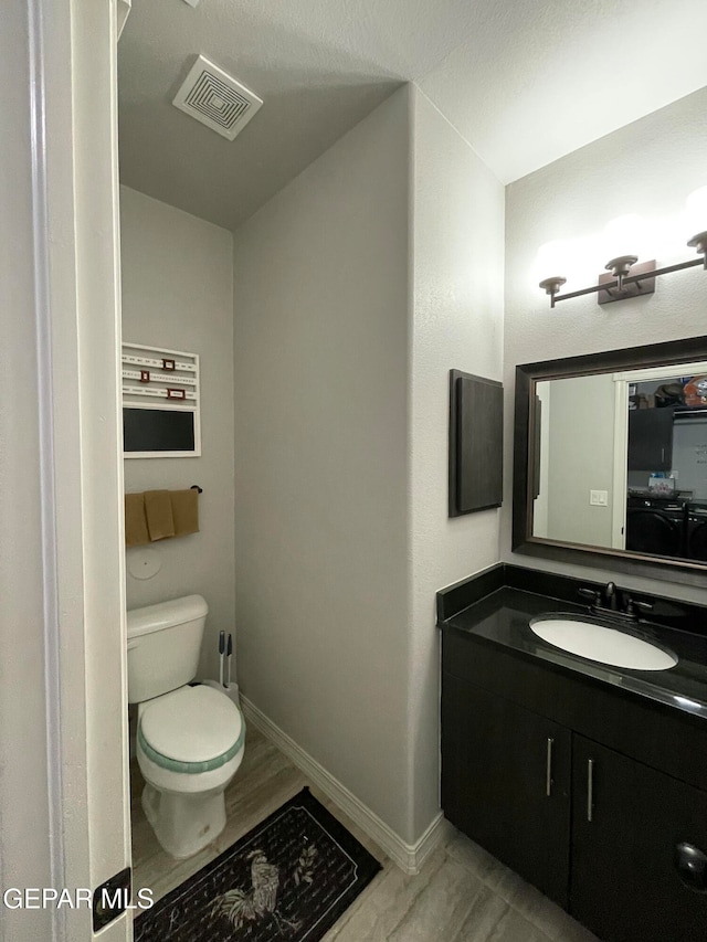 bathroom featuring vanity, toilet, and wood-type flooring